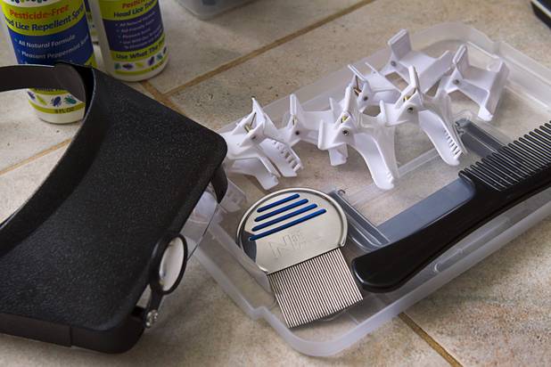 Michelle Lohrli, co-owner of Lice Happens, displays tools of the trade at her home Sunday, July 28, 2013. The business is part of a national franchise system.