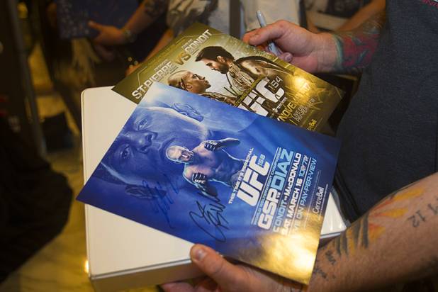 A UFC fan holds cards promoting former fights with UFC welterweight champion Georges St. Pierre of Canada during a UFC news conference in the lobby of the MGM Grand Monday, July 29, 2013. St. Pierre will defend his welterweight title against Johny Hendricks of Dallas, Texas during UFC 167 on Nov. 17 at the MGM Grand.