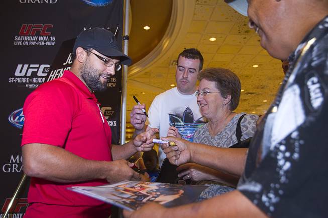 UFC fighter Johny Hendricks of Dallas, Texas signs autographs for fans during a UFC news conference in the lobby of the MGM Grand Monday, July 29, 2013. Hendricks will challenge UFC welterweight champion Georges St. Pierre of Canada for the title during UFC 167 on Nov. 17 at the MGM Grand.