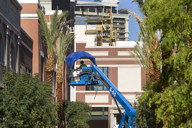 A worker uses a tarp for shade as he works in a lift at Caesars Entertainment's Linq development Tuesday, July 29, 2013. The $550 million shopping, dining and entertainment district will be anchored by the 550-foot-tall High Roller observation wheel. The project's first phase is expected to open in late 2013.