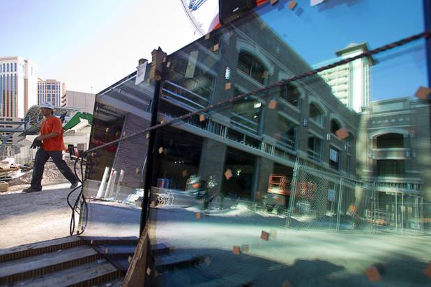 A worker walks by reflective glass during a tour of Caesars Entertainment's Linq development Tuesday, July 29, 2013. The $550 million shopping, dining and entertainment district will be anchored by the 550-foot-tall High Roller observation wheel. The project's first phase is expected to open in late 2013.