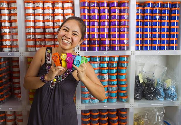 Designer Winky Wu poses with slap band watches in her office Tuesday, July 30, 2013. Wu is founder of Winky Designs, a Vegas-based company that makes accessories like bright, fun watches, purses and belts.
