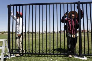 Max Alvarrez, left, and Luciano Alvarrez from Tiberti Co. Fence Division build a fence around the soccer field at Tropical Breeze Park in North Las Vegas on Tuesday, July 30, 2013.