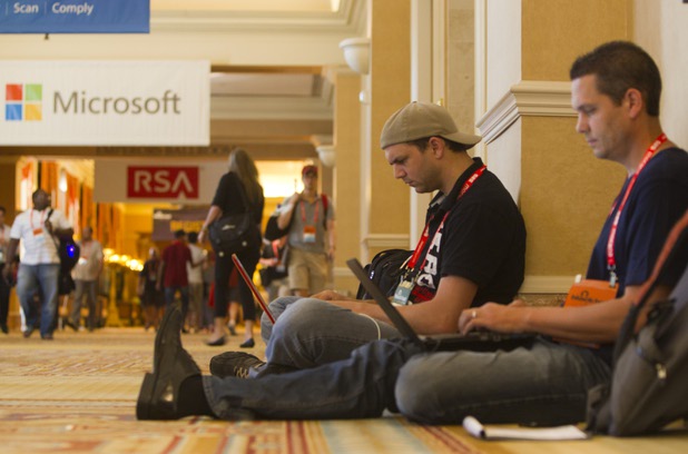 Black Hat USA 2013 attendees identified as "Mubix," center, and "bl4ck0ut" work on laptops in a hallway during the Black Hat hacker convention at Caesars Palace Wednesday, July 31, 2013.