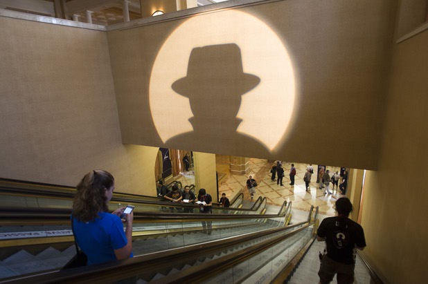 Black Hat USA 2013 attendees pass under a projected Black Hat logo during the hacker convention at Caesars Palace Wednesday, July 31, 2013.