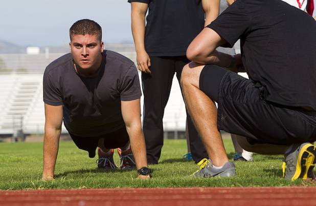 Metro Police recruit candidate Sean Pascoe, 21, performs 24 push-ups during physical fitness testing at Cimarron-Memorial High School Thursday, Aug. 1, 2013.