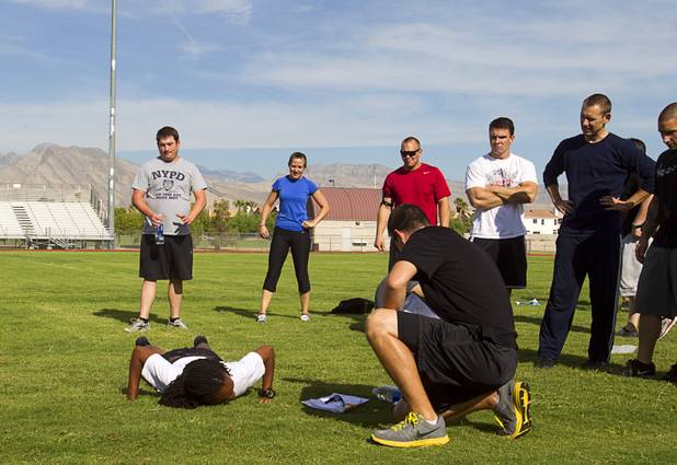Metro Police recruit candidate sags to the ground after failing to do the required 24 push-ups during physical fitness testing at Cimarron-Memorial High School Thursday, Aug. 1, 2013.