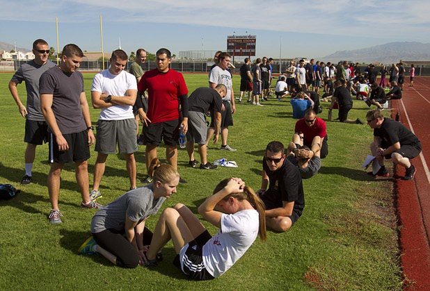 Metro Police recruit candidate Nicolette Hawkins, left, 22, holds the feet of Katy Koehne, 22, during  physical fitness testing at Cimarron-Memorial High School Thursday, Aug. 1, 2013. Candidates need to perform 32 sit-ups in one minute.
