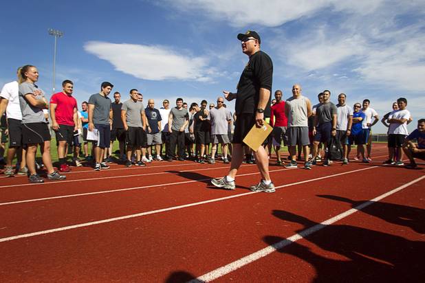 Metro Police recruiting officer Fred Castle briefs recruit candidates before a one mile run during physical fitness testing at Cimarron-Memorial High School Thursday, Aug. 1, 2013. The run must be completed in 10 minutes and 49 seconds or less.