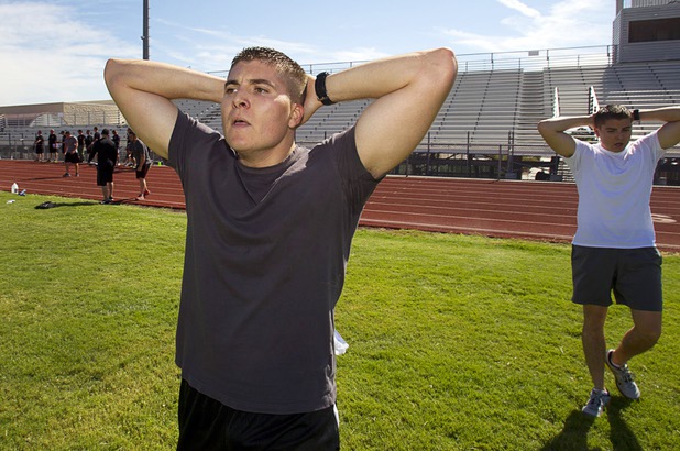 Metro Police recruit candidates and twin brothers Sean, left, and Chris Pascoe, 21, recover after a mile run during  physical fitness testing at Cimarron-Memorial High School Thursday, Aug. 1, 2013. The mile run must be completed in 10 minutes and 49 seconds or less.