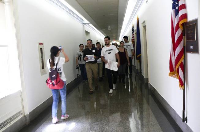 Immigration activists walk down a hallway of the Longworth House Office Building in Washington, D.C., heading to House Speaker John Boehner's constituent office as part of an immigration demonstration Thursday, July 31, 2013.