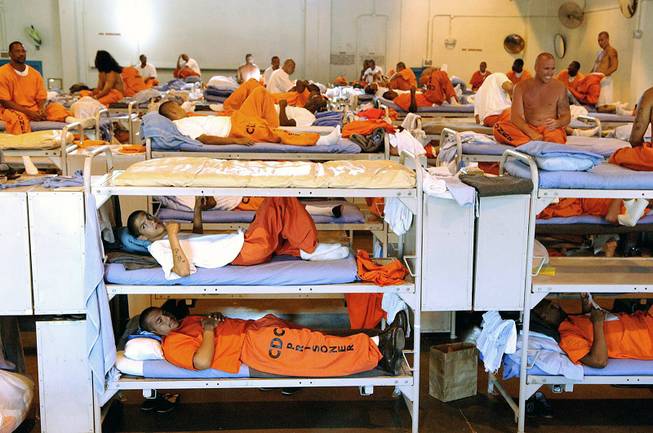 In this undated file photo released by the California Department of Corrections, inmates sit in crowded conditions at California State Prison in Los Angeles. 