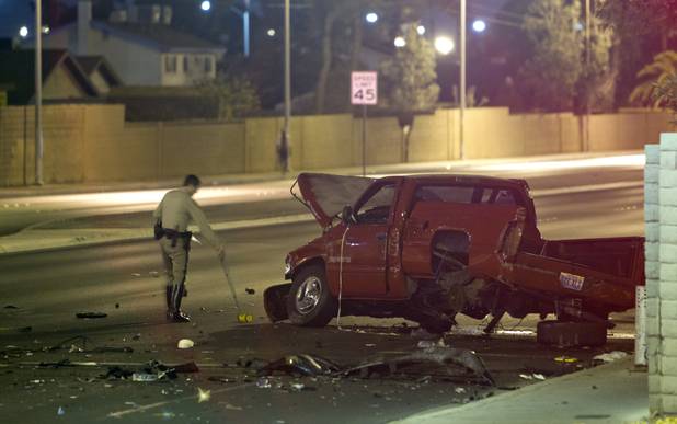 A Metro police officer takes measurements at an accident scene Saturday, Aug. 3, 2013. Several people were reported injured in the accident.