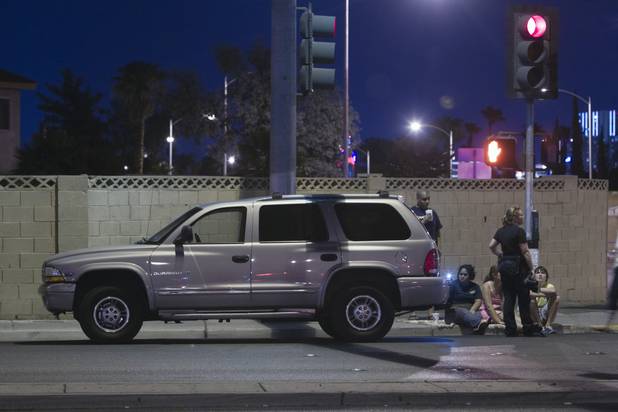 People wait by a vehicle as Metro police investigate an accident involving five vehicles, including a limousine, at Rainbow Boulevard and Twain Avenue on Saturday, Aug. 3 2013. Several people were reported injured in the accident.