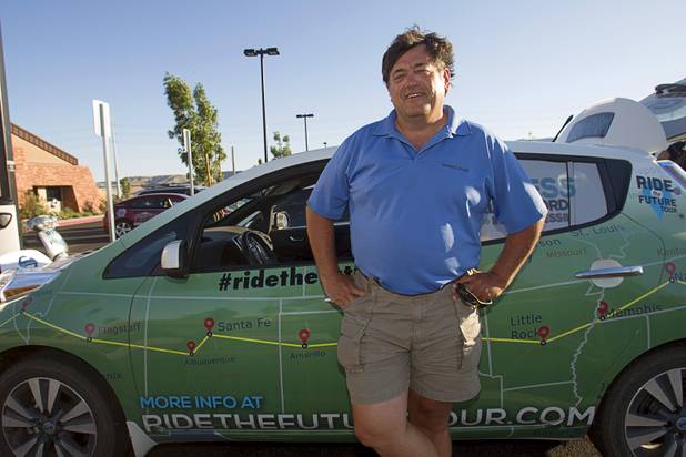 Duane Leffel, a member of the "Ride to the Future Tour" poses by a Nissan Leaf electric car after arriving at Las Vegas Cyclery near I-215 and Town Center Drive Sunday, Aug. 4 2013. The tour of electric vehicles hopes to be certified for several Guinness World Records. The cross-country tour began July 4th in Charleston, South Carolina, and will end at Google Headquarters in Mountain View, Calif. on August 16.