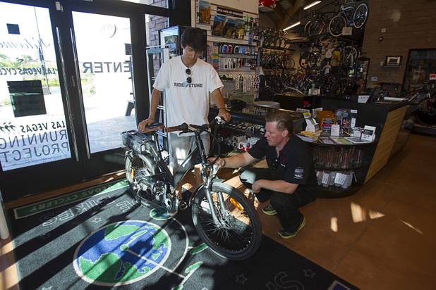 Sean Scott, a support staff member of the "Ride to the Future Tour," shows an electric bicycle to master technician Hugh Mason at Las Vegas Cyclery near I-215 and Town Center Drive Sunday, Aug. 4 2013. The tour of electric vehicles hopes to be certified for several Guinness World Records. The cross-country tour began July 4th in Charleston, South Carolina, and will end at Google Headquarters in Mountain View, Calif. on August 16.