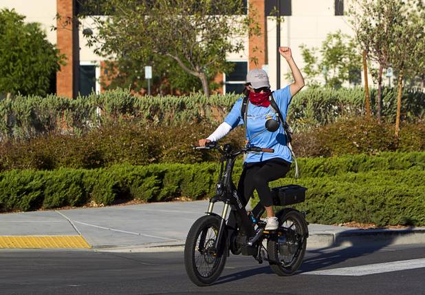Dominique Arciero, a member of the "Ride to the Future Tour," celebrates as she arrives by electric bicycle at Las Vegas Cyclery near I-215 and Town Center Drive Sunday, Aug. 4 2013. The tour of electric vehicles hopes to be certified for several Guinness World Records. The cross-country tour began July 4th in Charleston, South Carolina, and will end at Google Headquarters in Mountain View, Calif. on August 16.