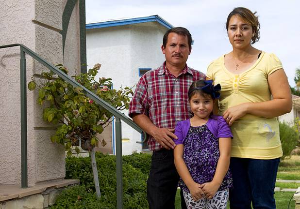 Jamileth Dominguez-Hernandez, 6, poses with her parents, Inocente  Jamilethz Dominguez and Maria Hernandez, outside the law offices of Langford McLetchie on Monday, Aug. 5, 2013. The family is suing Metro Police for failing to properly investigate when their daughter had her foot injured in an accident in 2011.