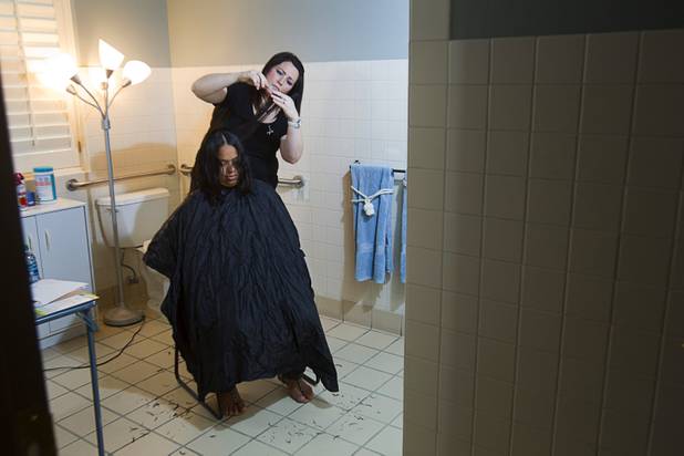 Mical Henderson cuts the hair of Sindy Alarcon at the Ronald McDonald House Monday, Aug. 5 2013. The The Ronald McDonald House provides temporary housing for families who travel to Las Vegas to receive critical medical treatment for their children.