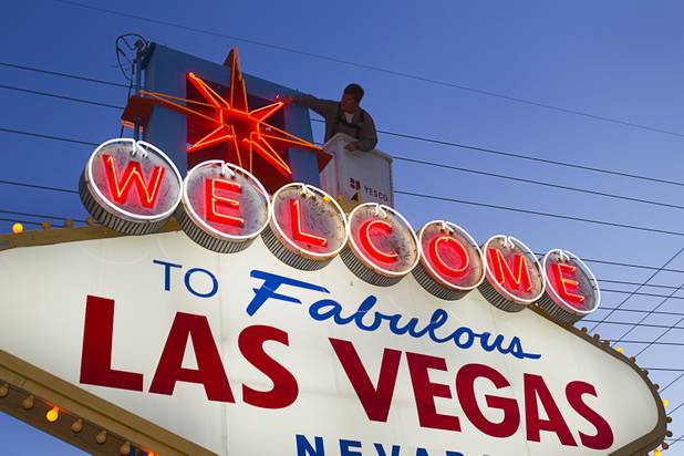 YESCO employee Kenny West services the Welcome to Las Vegas sign Wednesday, Aug. 7, 2013. West services the sign once a month and changes the 94 yellow bulbs around the sign perimeter, he said.