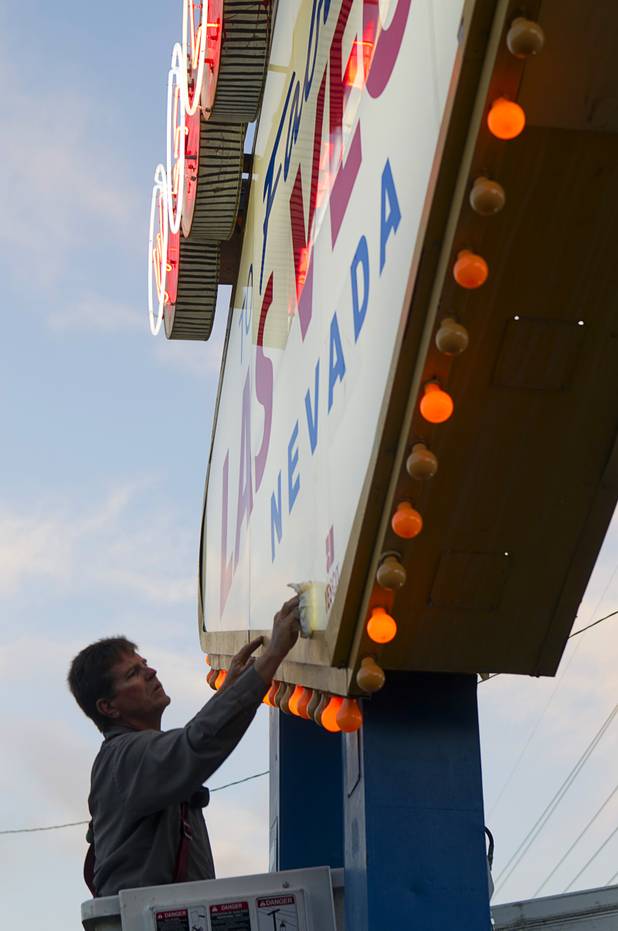 YESCO employee Kenny West services the Welcome to Las Vegas sign Wednesday, Aug. 7, 2013. West services the sign once a month and changes the 94 yellow bulbs around the sign perimeter, he said.