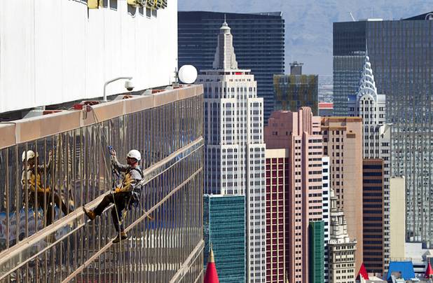 YESCO serviceman James Smith head to the roof after working on 9-foot neon tubes at the side of the Mandalay Bay Wednesday, Aug. 7, 2013.