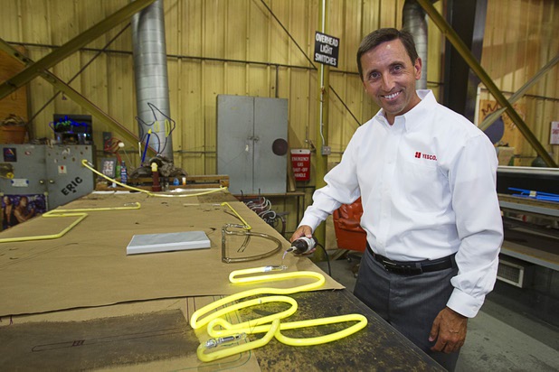 Jeff Young, YESCO senior vice president and chief marketing officer, poses with neon tubes at the Yesco facility in Las Vegas Wednesday, Aug. 7, 2013.