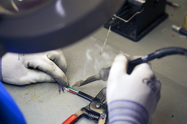 Corrie Dela Cruz connects  LED "pucks in a fabrication area at the YESCO facility in Las Vegas Wednesday, Aug. 7, 2013.