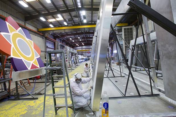 Workers sand a frame at the YESCO facility in Las Vegas Wednesday, Aug. 7, 2013. The frame will go around a high definition video display in the Energy Solutions Arena, the home of the Utah Jazz.