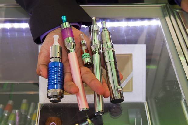 Ahmed Tebha, store manager of Evapor8, a hookah lounge and vapor boutique, displays a variety of e-cigarettes in the Neonopolis Mall in downtown Las Vegas Thursday, Aug. 8, 2013.