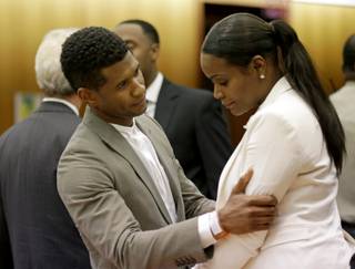 R&B singer Usher, left, embraces ex-wife Tameka Foster Raymond, after a judge dismissed an emergency request by Raymond seeking temporary custody of their two children, Friday, Aug. 9, 2013, in Atlanta. 