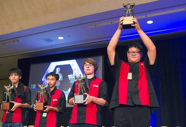 Shin En Huang, 24, of Taiwan holds up his first place trophy during the Yu-Gi-Oh! Trading Card Game world championships at Bally's Sunday, Aug. 11, 2013. Other players from left are: Hiromi Kudou of Japan (4th place), Weerapun Suebyoubol of Thailand (3rd place), and David Keener III of the U.S. Twenty-six players of the best players from around the world competed in the tournament.