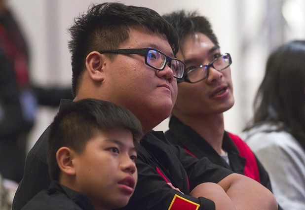 Yu An Li, 13, left, Shin En Huang, 24, center, of Taiwan, and Wingho Cheung, 24, of Hong Kong, watch the Dragon Duel competition during the Yu-Gi-Oh! Trading Card Game world championships at Bally's Sunday, Aug. 11, 2013. Huang later defeated David Keener III to win the world championship.