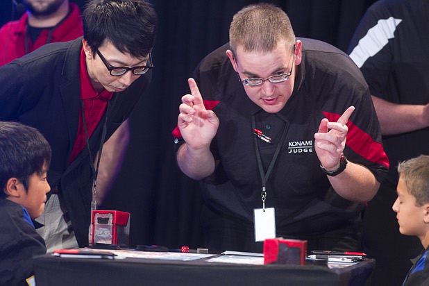A judge talks with Mao Goto, left, of Japan and Oliver S. Tomajko of the U.S. during the Yu-Gi-Oh! Trading Card Game world championships at Bally's Sunday, Aug. 11, 2013. A Japanese interpreter stands next to the judge. Twelve players competed in the Dragon Duel for players 12-years-old and younger. Tomajko beat Goto for first prize in the division.