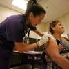 Crystal Wills, a nursing student with Concordia University out of Austin, Texas, inoculates Maria Guadalupe Torres on Wednesday morning, July 31, 2013, during Operation Lone Star at Manzano Middle School in Brownsville, Texas. 