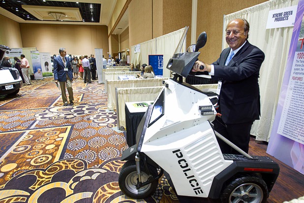Byron Georgiou poses on an Xtreme Green electric vehicle during the National Clean Energy Summit 6.0 at the Mandalay Bay Tuesday, Aug. 13, 2013.