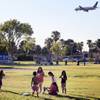 Kids play at Sunset Park in Las Vegas as an airplane lands at McCarran International Airport on Tuesday, Aug. 13, 2013.