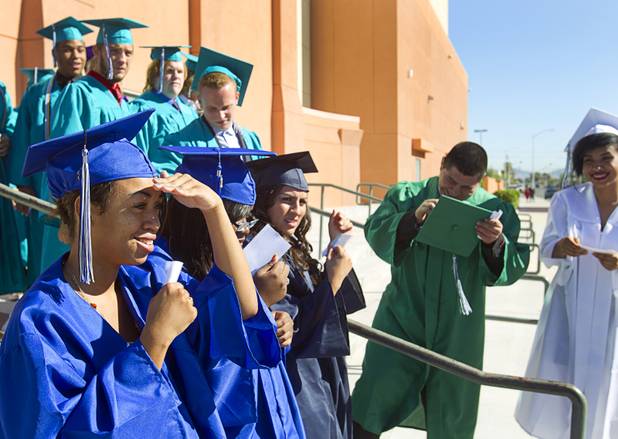Breanna Rodriguez, left, of Desert Pines High School shields her eyes from the sun as she waits with other students before the Clark County School District's second annual summer high school graduation ceremony for summer school graduates and at-risk students at the Las Vegas Academy in downtown Las Vegas Wednesday, Aug. 14, 2013.