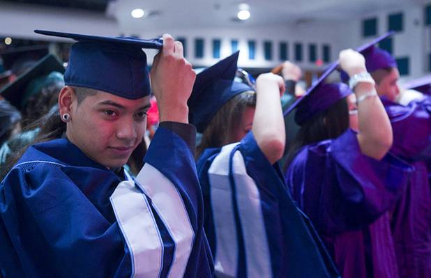 Adrian Gamez, left, of Canyon Springs High School moves his tassel from the right to the left at the conclusion of the Clark County School District's second annual summer high school graduation ceremony for summer school graduates and at-risk students at the Las Vegas Academy in downtown Las Vegas Wednesday, Aug. 14, 2013.