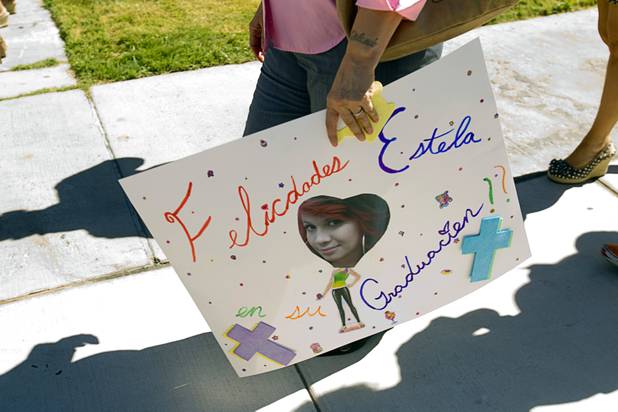 A family member carries a poster following the Clark County School District's second annual summer high school graduation ceremony for summer school graduates and at-risk students at the Las Vegas Academy in downtown Las Vegas Wednesday, Aug. 14, 2013.