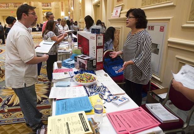 Robert Hollowood, left, talks with Letty Elias, assistant executive director of the Clark County Education Association, as they recruit new members for the union during a Clark County School District orientation session for new teachers at the Venetian Thursday, Aug. 15, 2013. Over 1,700 teachers took part in the orientation.