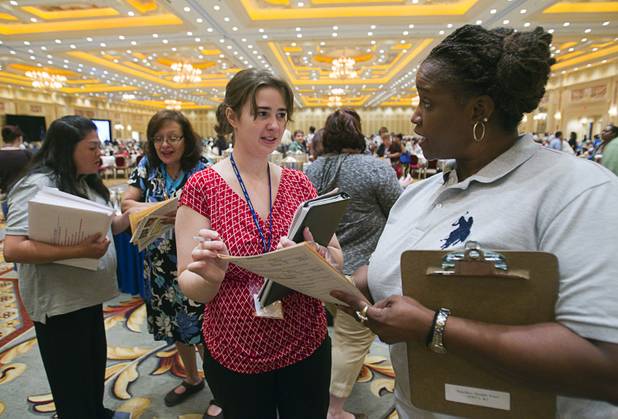 New teacher Amanda Ford, center, talks with Candy Smith, service director for the Teachers Health Trust, during a Clark County School District orientation session for new teachers at the Venetian Thursday, Aug. 15, 2013. Over 1,700 teachers took part in the orientation.