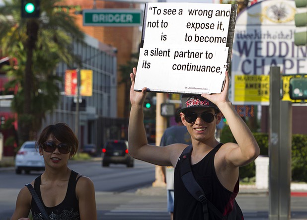 Nicandro Gomez carries a sign with a quote by John Raymond Baker during a protest in support of Army Pfc. Bradley Manning in front of the Lloyd George Federal Building in downtown Las Vegas Wednesday, Aug. 21, 2013. A military judge sentenced Manning to 35 years in prison for leaking hundreds of thousands of classified documents to WikiLeaks.