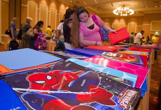 A teacher looks over a table covered with folders during MGM Resorts' annual Educator Appreciation Day and Back to School Fair at the Mirage Thursday, Aug. 22, 2013. More than 18,000 teachers were invited to gather schools supplies donated by MGM Resorts employees.