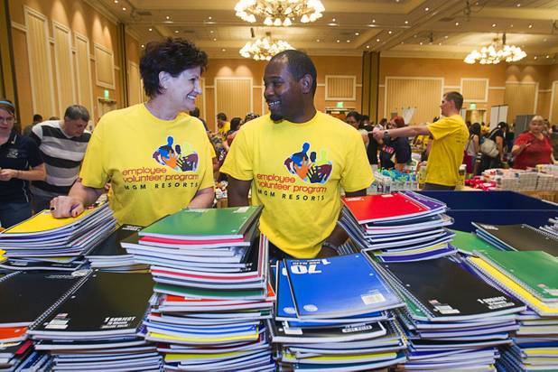 Volunteers Kay White, left and Samuel Mullings stock a table with notebooks during MGM Resorts' annual Educator Appreciation Day and Back to School Fair at the Mirage Thursday, Aug. 22, 2013. White is a poker room manager at the Mandalay Bay. Mullings is finance student in the MGM Resorts' management action program.
