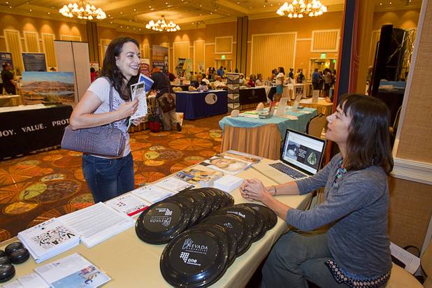 Erin Ko, a music teacher at C.T. Sewell Elementary School, gets information from Rachel Hopkin, program coordinator for Nevada Humanities, during MGM Resorts' annual Educator Appreciation Day and Back to School Fair at the Mirage Thursday, Aug. 22, 2013. More than 18,000 teachers were invited to gather schools supplies donated by MGM Resorts employees.