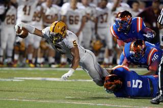 Mountain Pointe running back Wesley Payne stretches for yards while being tackled by Bishop Gorman's Ryan Garrett during their Sollenberger Classic game at Bishop Gorman Friday, Aug. 13, 2013.
