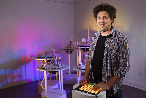Artist David Sanchez Burr stands by a control panel in front of the New Citadel at the P3 Gallery in the Cosmopolitan Sunday, Aug. 25, 2013.