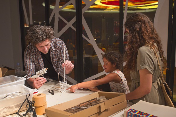 Artist David Sanchez Burr takes direction from Katelyn Lopez, 8, of Long Beach, as he creates a sculpture for the New Citadel at the P3 Gallery in the Cosmopolitan Sunday, Aug. 25, 2013.