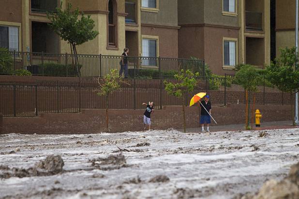 A child throws a rock into storm runoff on Grand Teton Drive near Grand Canyon Drive Sunday, Aug. 25, 2013.
